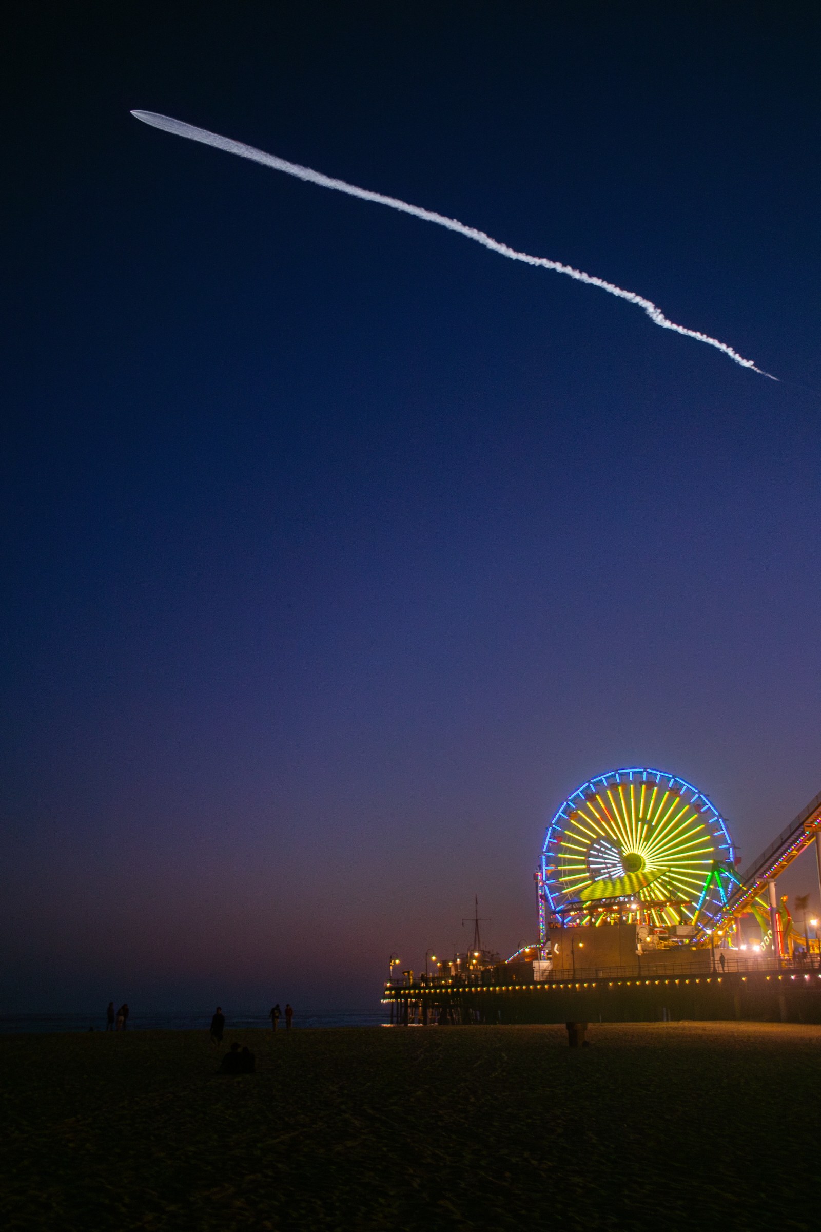 Founders: rocket launch trail over the Santa Monica Pier Ferris wheel at dusk